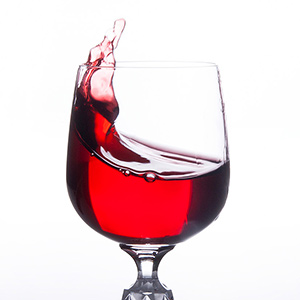 Red wine splashing in wine glass